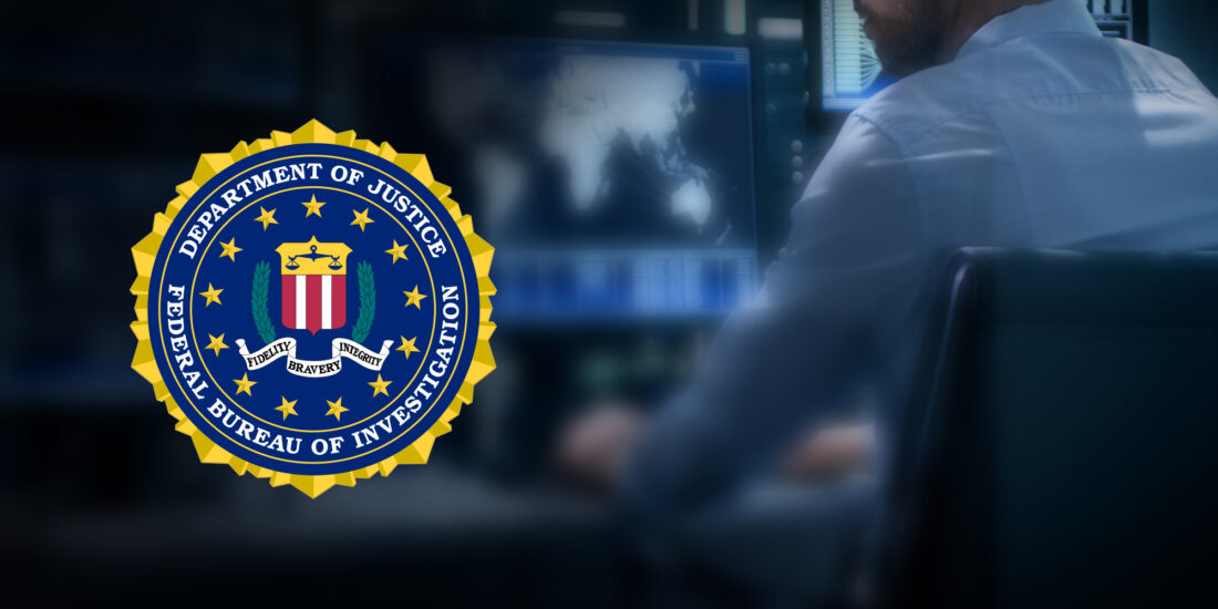 FBI Symbol Over a Man Working on a Computer