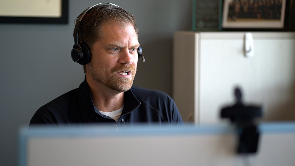 Image of a SOC Analyst with a headset talking to a customer over the phone.