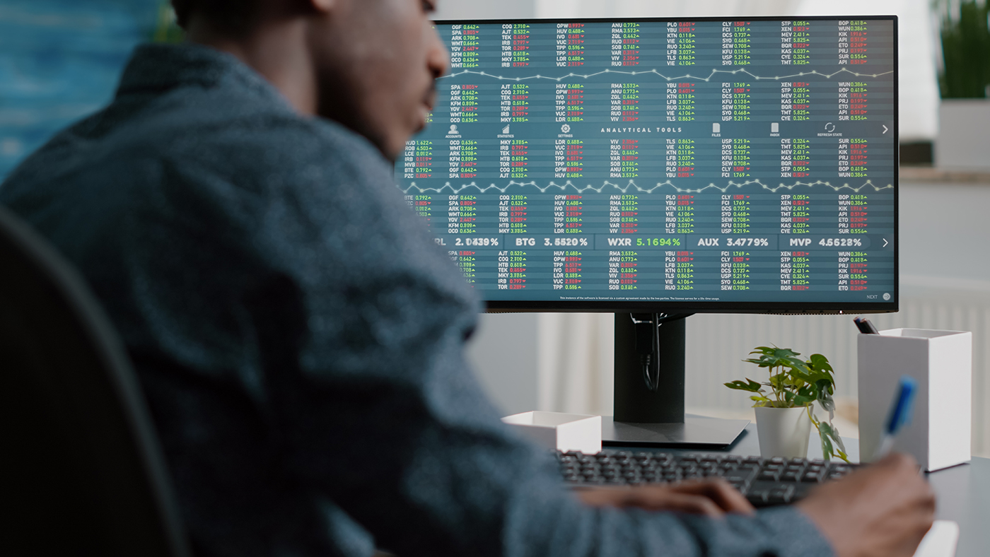 A professional working on cybersecurity in the financial sector, following SEC cybersecurity guidance. The person is seated in front of a large monitor displaying a complex array of stock market analytics and data encryption measures. This workspace exemplifies a secure environment for monitoring and protecting sensitive financial data against cyber threats, in compliance with regulatory standards for security and confidentiality in the stock exchange market. A professional working on cybersecurity in the financial sector, following SEC cybersecurity guidance. The person is seated in front of a large monitor displaying a complex array of stock market analytics and data encryption measures. This workspace exemplifies a secure environment for monitoring and protecting sensitive financial data against cyber threats, in compliance with regulatory standards for security and confidentiality in the stock exchange market.