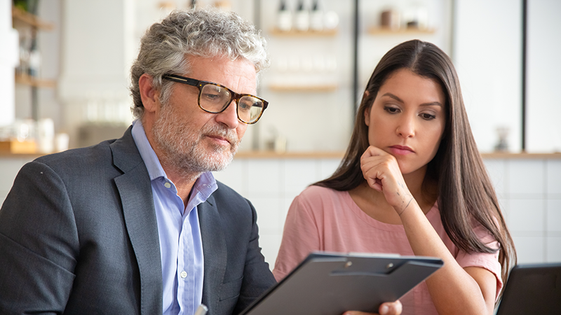 A man and woman looking at a technology plan for e-rate funding.
