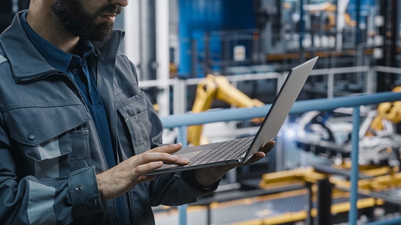 Man in manufacturing environment with computer
