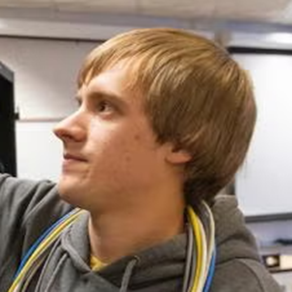 Young person with blond hair in a gray hoodie, shown in a side profile looking upward.